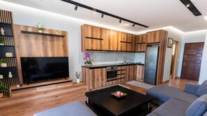 Una cocina moderna con armarios de madera, horno empotrado y encimera negra.