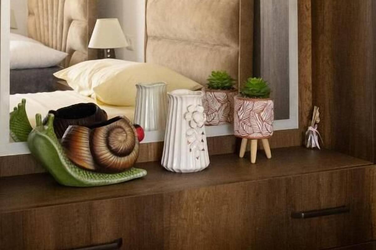 A bedroom with a large bed, bedside tables, a mirror, and a painting on the wall.