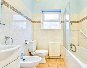 A bathroom with a toilet, bidet, sink, and a shower area. - Cosy garden flat in Finchley, North London - Pass the Keys (London)