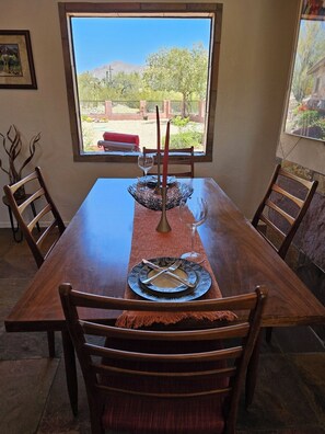 A dining table set with plates, cutlery, and candles, with chairs around it. - Quintessential Tucson 2 -  2BR 2BA Adobe House with Office and VIEWS! (Tucson)