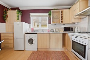 Eine moderne Küche mit Waschmaschine, Mikrowelle und Backofen.