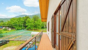 A balcony with a view of a tennis court, a car, and a mountainous landscape. - All'antico Peso - Two Bedroom Apartment, Sleeps 5 (Festiona)