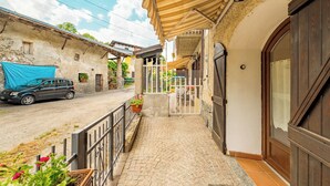 A residential property with a paved driveway, a covered porch, and a large wooden door.