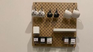 Un área de comedor con un panel de aglomerado mostrando tazas y una estación de café.