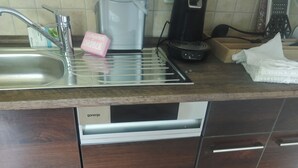 A kitchen with a stainless steel sink, a coffee maker, and a dishwasher. - Vacation apartment on the Nordschleife (Wimbach)