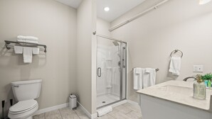 A modern bathroom with a toilet, shower, and sink.