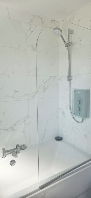 A bathroom with a glass-enclosed shower, a white marble wall, and a built-in control panel. - Large House, Sleeps 7, Perfect for Long term stays (Cottam)