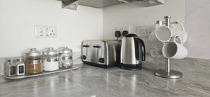 A kitchen with a toaster, coffee maker, and a mug rack. - Large House, Sleeps 7, Perfect for Long term stays (Cottam)