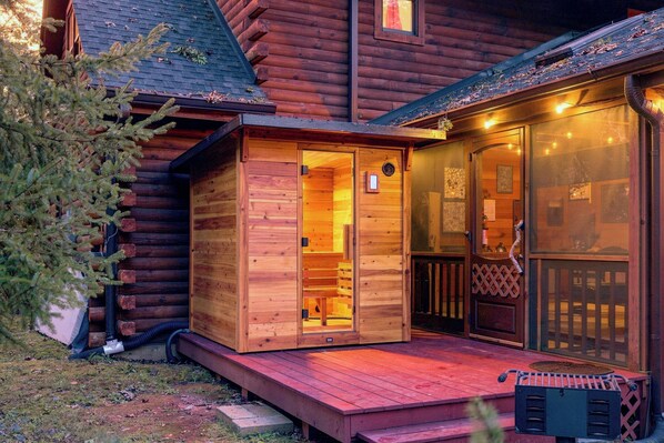 A wooden cabin with a porch and a covered entryway.