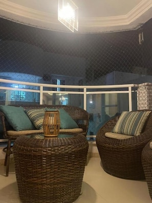 A balcony with wicker furniture, a glass enclosure, and a view of the outside. - BALEARIC ISLANDS | Angra dos Reis (Angra dos Reis)