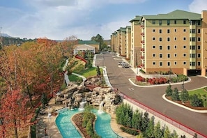 A hotel with a swimming pool, a waterfall, and a parking lot. - RiverStone Resort • Upscale 1BR•1BA Condo · Sleeps 4• Lazy River•Pool•Hot Tubs (Pigeon Forge)