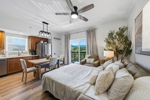 A modern bedroom with a large bed, a desk, and a balcony with a view. - RiverStone Resort • Upscale 1BR•1BA Condo · Sleeps 4• Lazy River•Pool•Hot Tubs (Pigeon Forge)