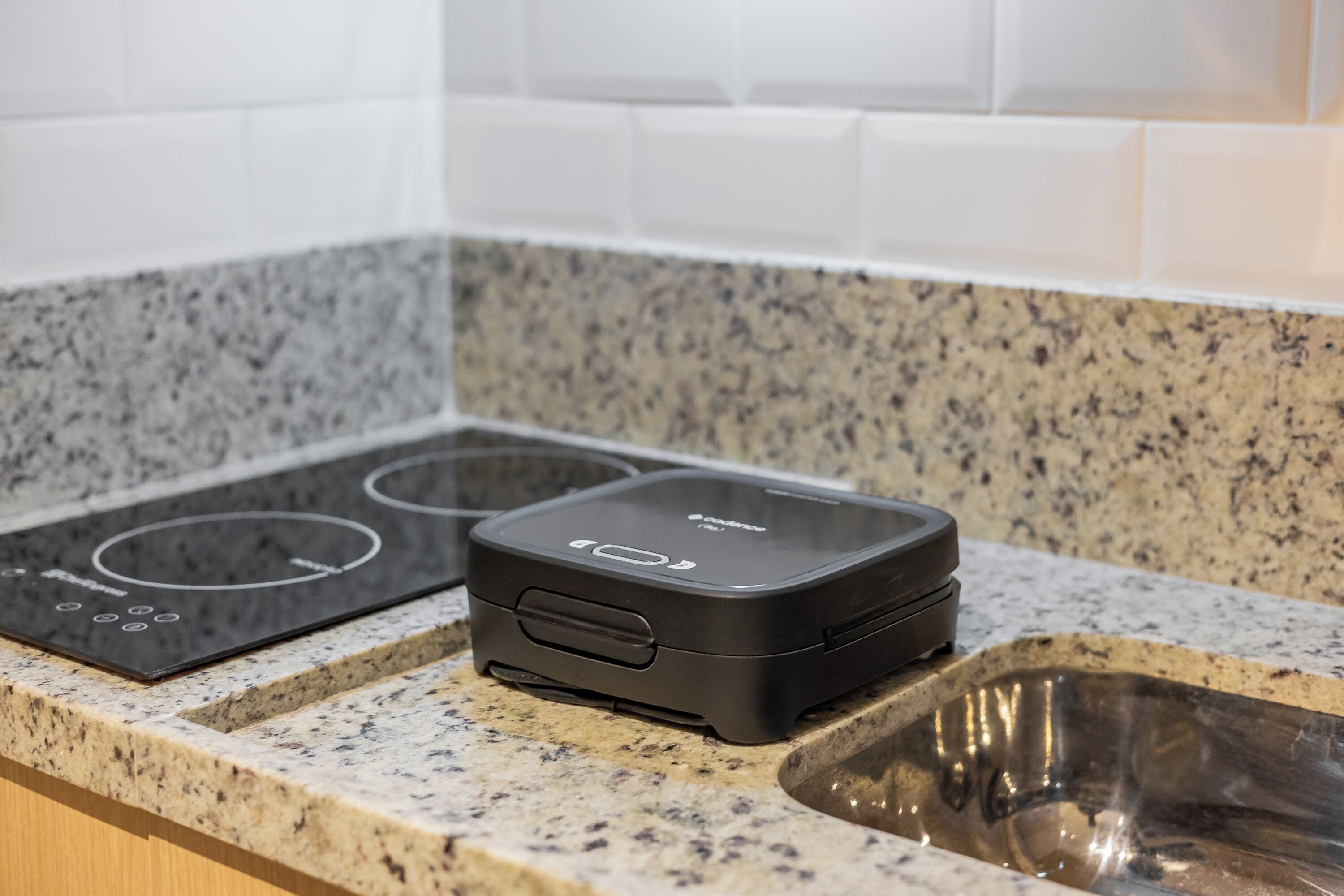 A kitchen with a granite countertop, a built-in stove, and a sink.
