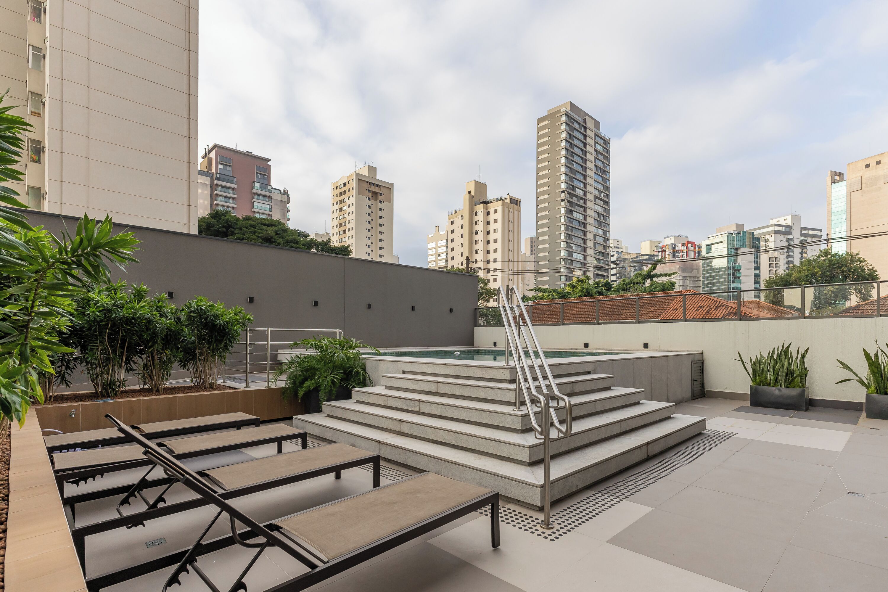 Terraza en la azotea con piscina, escalones y zonas de estar.