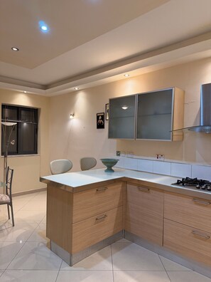 Een moderne keuken met een centraal eiland, inbouwkeukens en een gasfornuis.