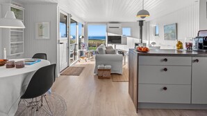 Een modern interieur met een eethoek, keuken en uitzicht op de omgeving.