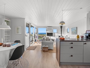 Ein modernes Interieur mit Essbereich, Küche und Blick ins Freie.