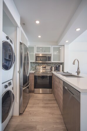 A modern kitchen with stainless steel appliances, a dishwasher, and a built-in oven.