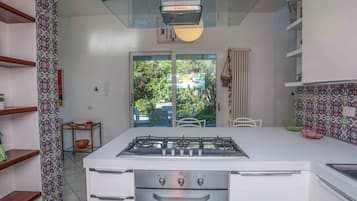 A modern kitchen with a central island, a built-in oven, and a gas stove.
