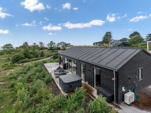 Ein modernes Haus mit flachem Dach, großen Fenstern und einer Terrassenfläche.