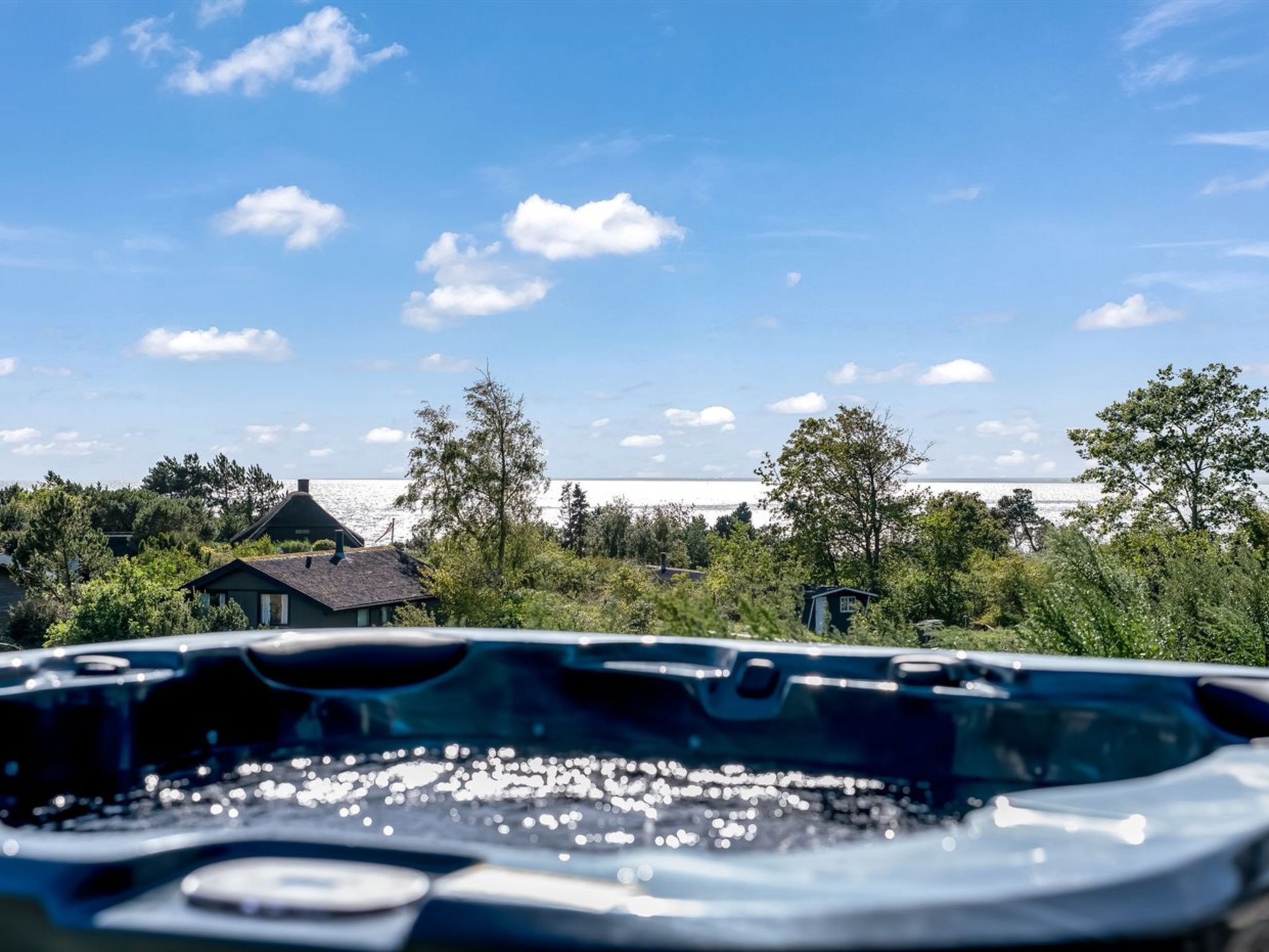 Autoinnenraum mit Blick auf eine Wohngegend und ein Gewässer im Hintergrund.