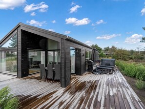 A modern house with a deck, outdoor seating, and a barbecue area. - "Theodora" - 600m from the sea by Interhome (Knebel)