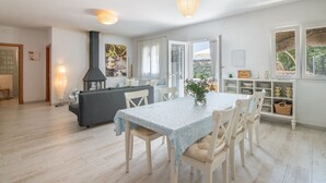A modern kitchen with a dining area, a built-in stove, and a view through the open door. - La Soberana: The House That Cares for You (Arroyo)