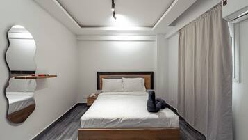 A modern hotel room with a wooden bed, a nightstand, a mirror, and a window with curtains.