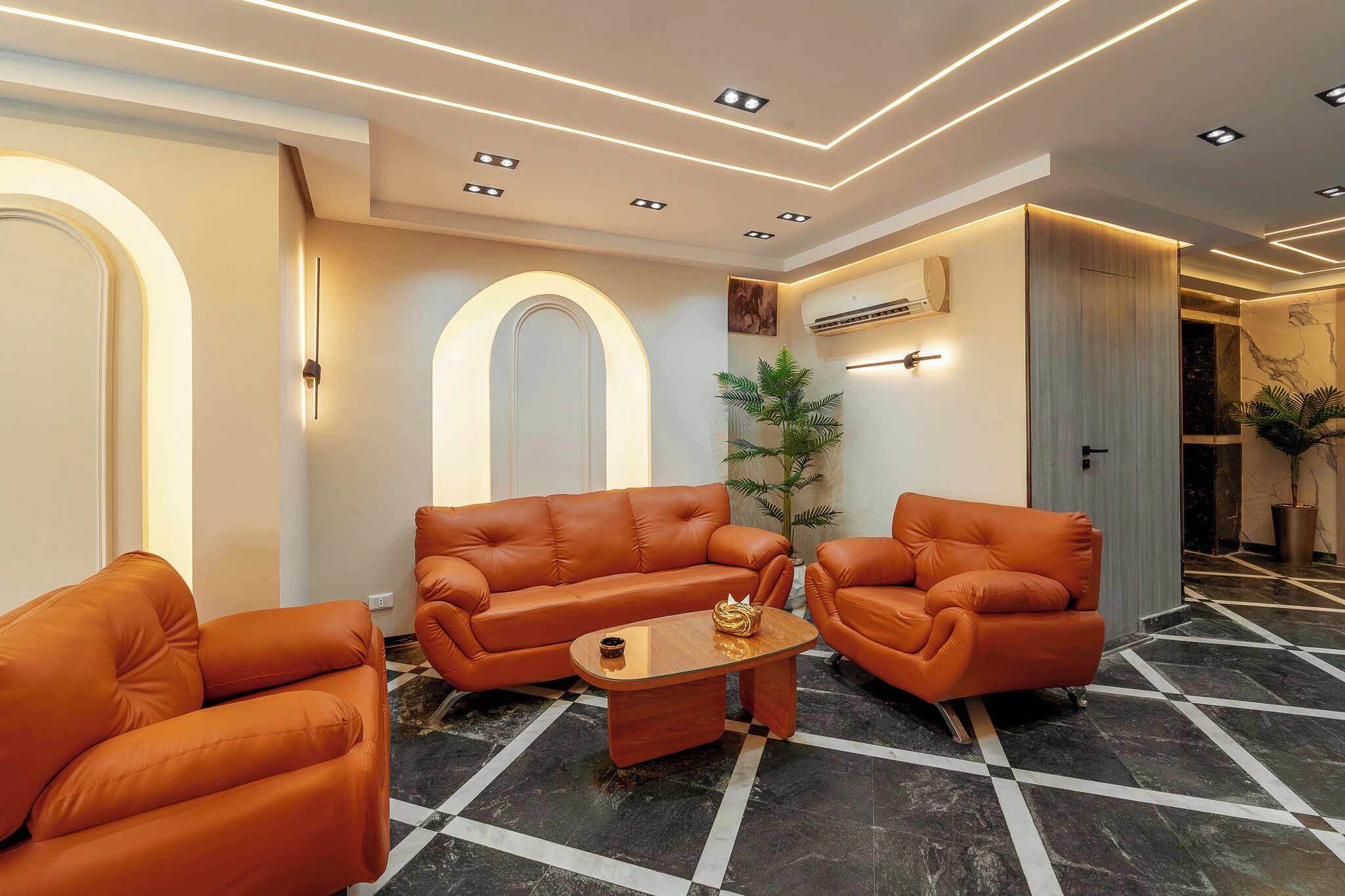 Eine moderne Hotelhalle mit Ledersofas, einem Holztisch und einem Schachbrettmuster-Boden.