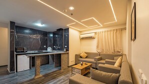 Un espacio habitable moderno con cocina, sofá y una mesa de centro.