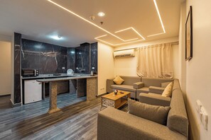 A modern living space with a kitchen, sofa, and a coffee table. - Daas Suite & Residence Cairo (Cairo Governorate)