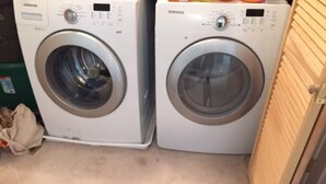 Two Samsung washing machines in a laundry room with a green container and a beige bag on the floor. - Charming 3-bedroom cottage in lovely Vinalhaven perfect for relaxing (Vinalhaven)