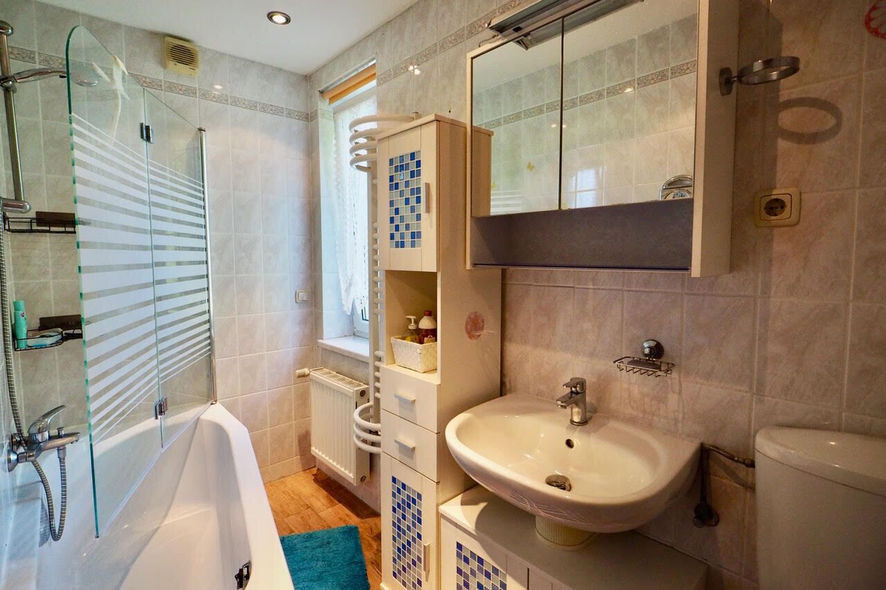 Une salle de bain équipée d’une baignoire, d’un lavabo, de toilettes et d’une douche à parois de verre.