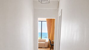 Un pasillo con un radiador que conduce a una habitación con vistas al mar.
