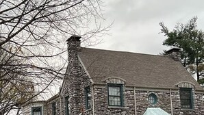 A stone house with a gabled roof, multiple windows, and a covered porch. - Beautiful Duplex in the heart of Lexington (Lexington)