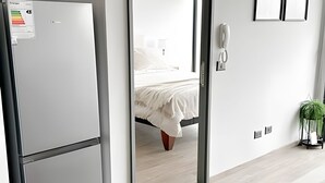 A modern hotel room with a bed, a telephone, and a small plant. - Depto. moderno y acogedor I Wifi I AC (Santiago)