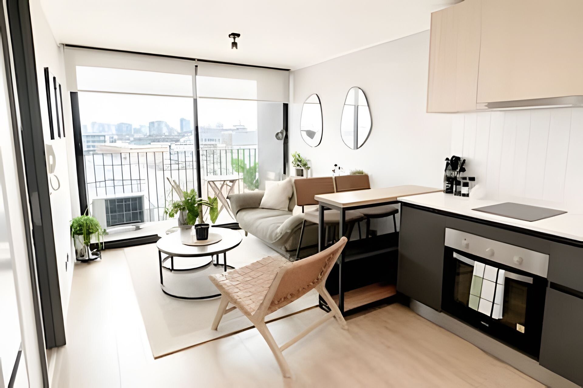 A modern kitchen with a dining area, large windows, and a view of the city.