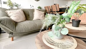 A living room with a sofa, a coffee table, and various plants. - Depto. moderno y acogedor I Wifi I AC (Santiago)
