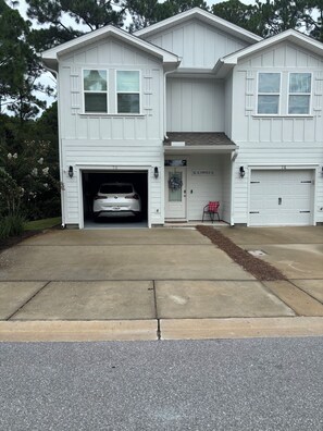 A two-story house with a garage, a driveway, and a front porch. -  Seaglass Sassy’s Beach House Your Santa Rosa Beach Escape (Santa Rosa Beach, Florida)
