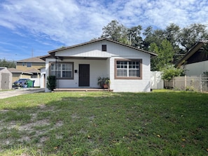 A single-story house with a front porch, a garage, and a fenced yard.