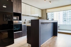 Una cocina moderna con horno empotrado, microondas y fregadero.