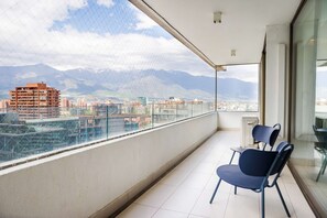 A balcony with a view of a cityscape and mountains. - Luxury 2 Bedroom Apartment with Pool and Parking (Las Condes)