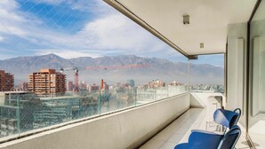 Ein Balkon mit freiem Blick auf eine Stadtlandschaft und Berge im Hintergrund.