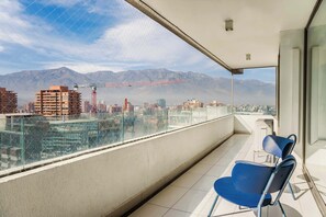 Ein Balkon mit freiem Blick auf eine Stadtlandschaft und Berge im Hintergrund.