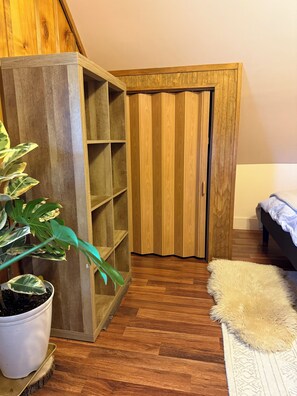 A room with a wooden bookshelf, a potted plant, a fluffy rug, and a bed. - A Cozy Retreat tucked into one of Fork‘s historic industrial neighborhoods (Forks)