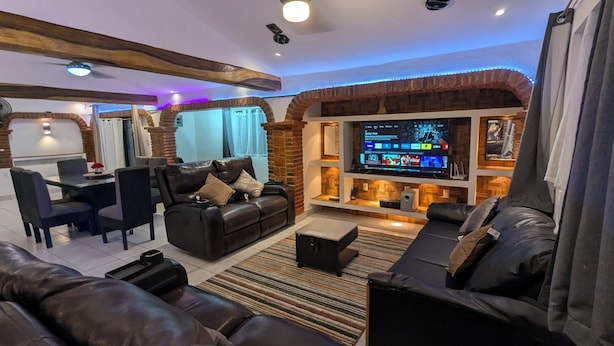 Una sala de estar con chimenea, televisor y zona de estar.