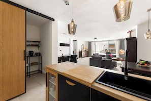 A modern kitchen with a wooden countertop, black cabinetry, and pendant lighting. - Home2Book Elegant Villa with Jacuzzi Costa Teguise (Teguise)