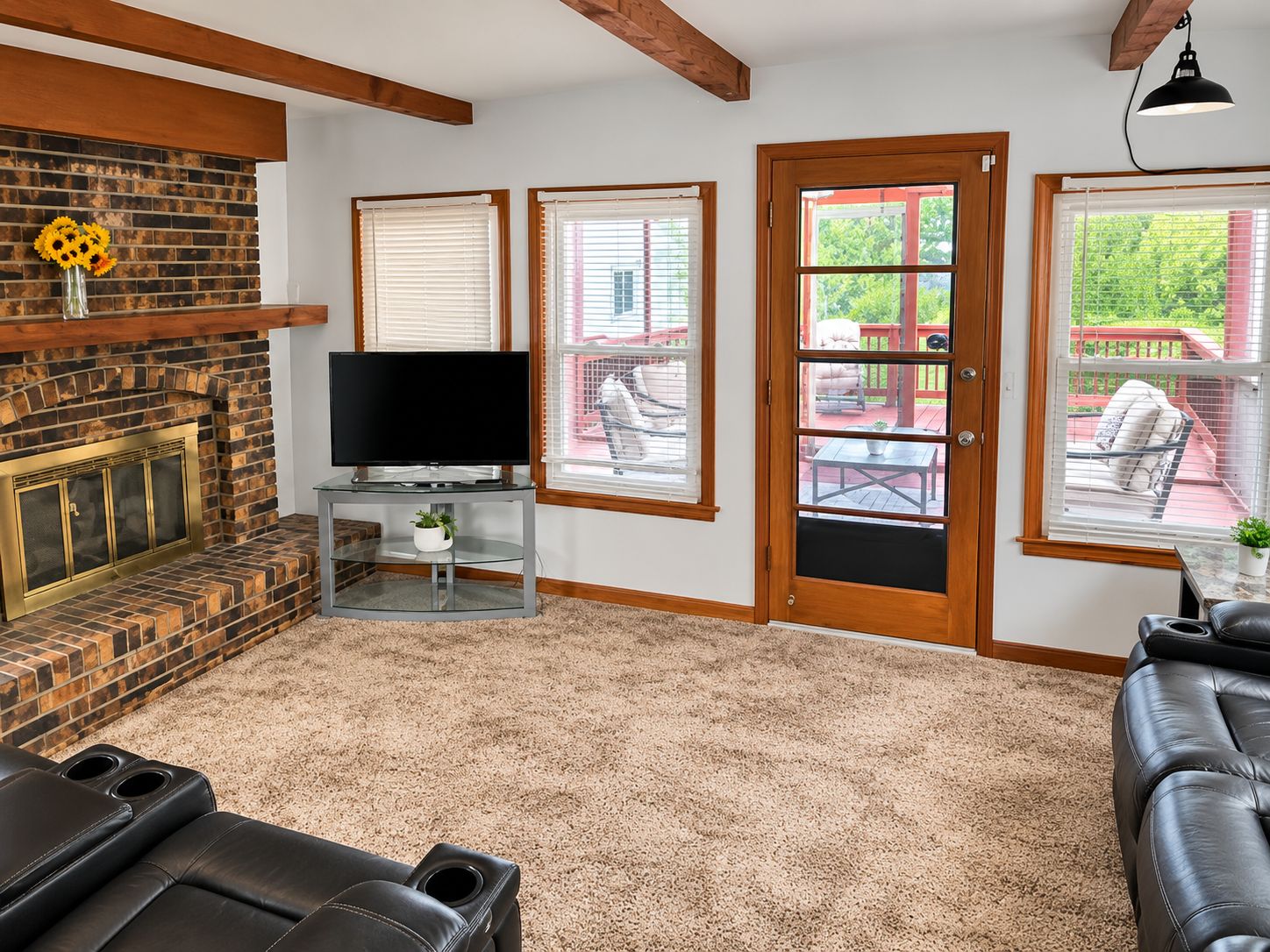 A living room with a fireplace, a television, and a seating area with a sofa and chairs.