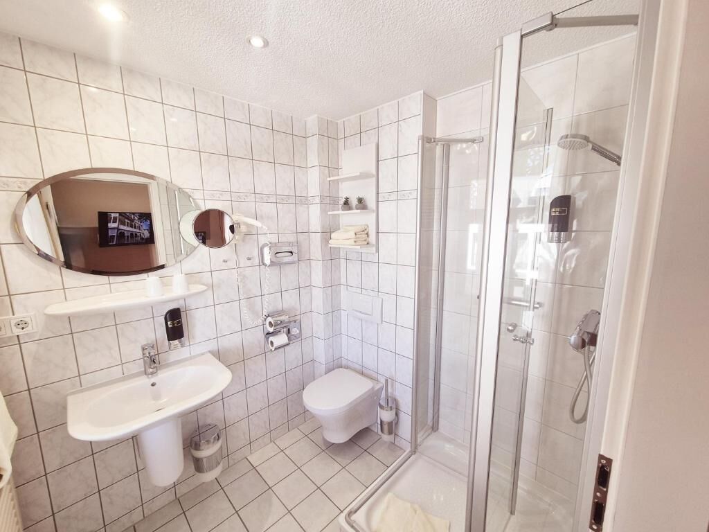 Un baño con lavamanos, inodoro y ducha.
