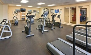 Ein Fitnessraum mit Laufbändern, Crosstrainern und einem Ergometer.